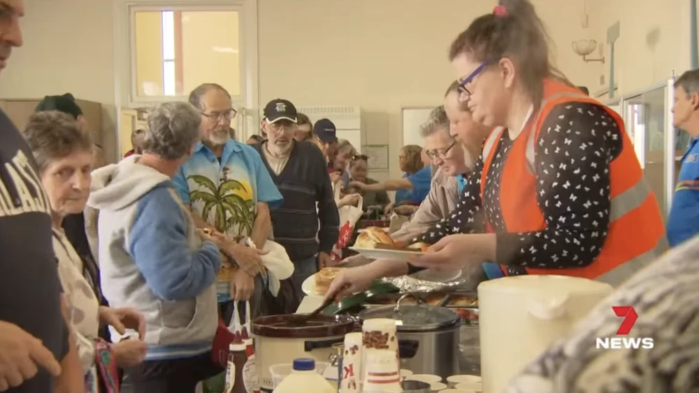 A CHATS volunteer serving a meal